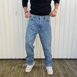 Levi's 550 jeans i ljusblå denim - 36/32 - Säljer ett par klassiska Levi's 550 jeans i ljusblå denim. De har en relaxed fit och är perfekta för en avslappnad stil. Jeansen är i bra skick och har den ikoniska Levi's-lappen bak. Perfekta för både vardag och chill.