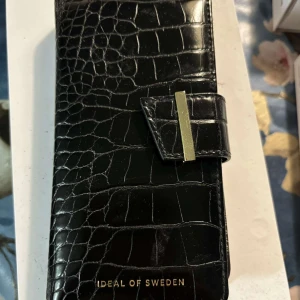 Oanvänt ideal of Sweden frodral - Ett frodral + tillhörande svart skal till IPhone 12 från Ideal of Sweden. Helt oanvänt. Nypris 399kr