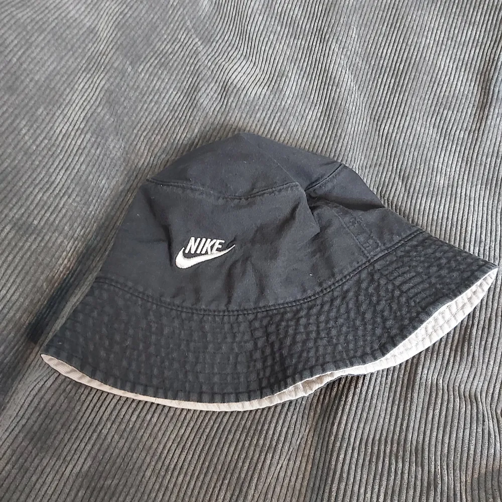 Snygg buckethat från Nike som tyvärr blivit för liten. Är ca 55 cm runtom. Är i en mörktblå/grå, lite urtvättad färg.. Accessoarer.