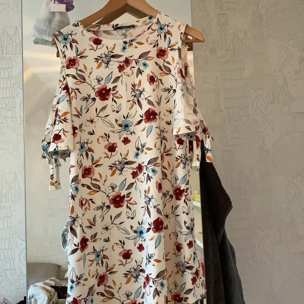 En kort, somrig och blommig klänning från Mango i strl S. Ärmarna är också detaljerade med fina rosetter. Anledningen till att jag säljer är pga jag är 176 cm så den är lite för kort för min del.. Klänningar.