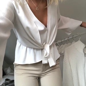 Vit blus - Vit blus från top shop, super söt. Skulle säga att det är storlek XS men funkar bra på mig som har S. Knytning i midjan som gör att den sitter fint. Budgivning🧡🧡