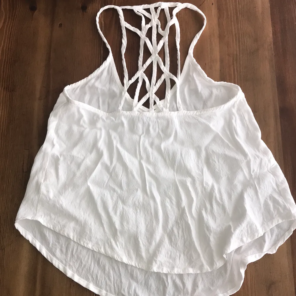 Super rare Brandy!! Disclaimer: Tiny hole on front. Soft woven tank in sheer white with a deep v-neck front with cross strap detailing and crisscross straps on the back. Shirttail hem. Polyester Elastane blend. Tag size OSFA. Smoke/pet free home. . Toppar.