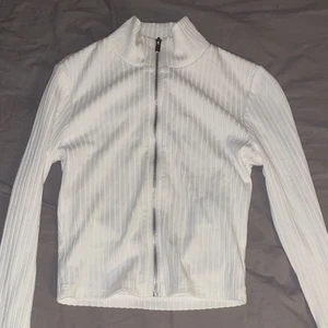 Vit topp med dragkedja - En vit topp med dragkedja. Storlek xs. Sitter snyggt på och är helt OANVÄND. Denna topp passar alla tjejer där ute i alla åldrar och former!💓