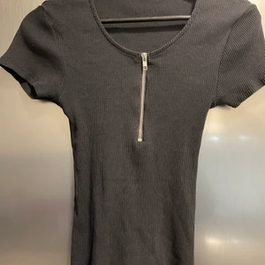 Svart topp - Snygg topp med dragkedja, väldigt stretchig. Knappt använd. Storlek L men är mer som en Medium.