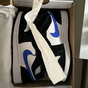 Nike Air Jordan 1 ”Racer Blue” - Nike Air Jordan 1 ”Racer Blue”. Storlek 40 men skulle mer säga att de passar 39 då jag själv har det i andra skor. Köpta i vintras från GOAT och är knappt använda. Lite creasade även fast jag använt crease skydd (ingår såklart). Väldigt bra skick, nästan helt nya. Original box med klistermärken ingår även. Om fler bilder önskas skriv privat . Frakten står köparen för!