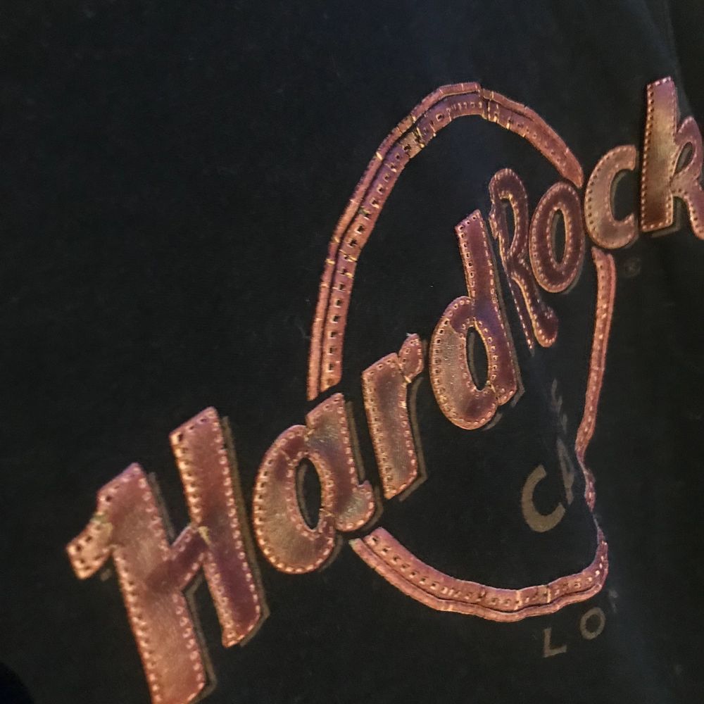 En svart Hard Rock Café t-shirt med tryck i läder, storlek small. Hard Rock Cafe t-shirt med tryck som står ut, från London.. T-shirts.