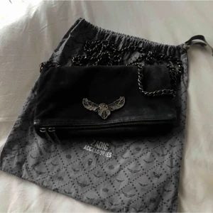 Zadig & Voltaire väska  - Säljer min zadig & Voltaire väska då den ej kommer till användning längre , väskan är välanvänd och har tappat lite färg på märket. Det kortare bandet har tappat ett ”lås” se 3 bild. Annars är väskan jättefin men säljer för 400kr pga skicket