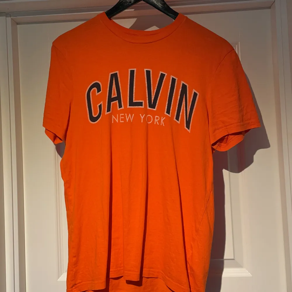 Orange Calvin Klein t-shirt i storlek s, äldre modell, med litet sytt slitage på ryggen, annars riktigt fin. T-shirts.