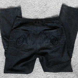 Svarta low waist jeans - Svarta lågmidjade jeans med detaljer på fickorna. Passar någon som är 160-170cm. Köpta second hand men de är i bra skick! Kan mötas upp i Stockholm eller står köparen för frakt