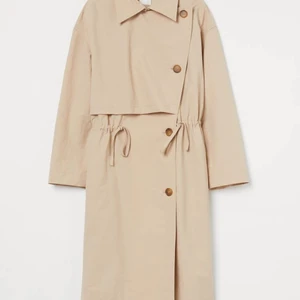 NY Trenchcoat (Storlek M, H&M) - Säljer denna trenchcoat från H&M. Helt ny med lapp kvar - oanvänd. Storlek M men passar S till L beroende på hur man vill att den ska sitta. Slutsåld på hemsidan och säljer den för 450 kr. Hör av dig om du är intresserad!