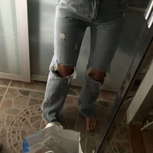 JEANS MED SLITNINGAR - skitnajs jeans med slitningar på knäna. ett par gamla favoriter som tyvärr ej kommer till användning. storlek s och går över foten på mig som är 173cm lång. skulle säga att den passar dig som har storlek 34 - 38 beroende på önskad passform. 