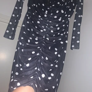 Nelly klänning - Oanvänd prickig klänning med etikett från Nelly.  Storlek XL men liten i modell så skulle säga att det egentligen är storlek M/L.  Väldigt fin och elegant klänning med fin detaljsöm längst framsidan. 