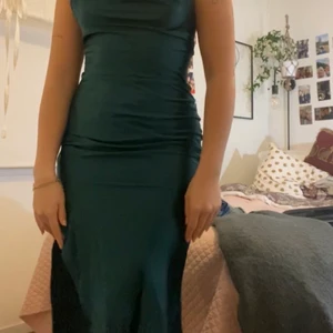 Satinklänning - En grön satinklänning med slits i ena benet, en riktigt fin klänning som tyvärr inte kommit till användning då jag känner att jag inte riktigt passar i den! Perfekt för allt från bak till en middagsklänning! Hör av er vid frågor! 🤍