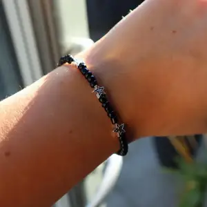 Super fint armband gjort av svarta pärlor och tre stjärnor på. Ingår spänne och ringödlor så man kan justera det efter önskad storlek. Man får även själv välja vilken storlek man vill ha