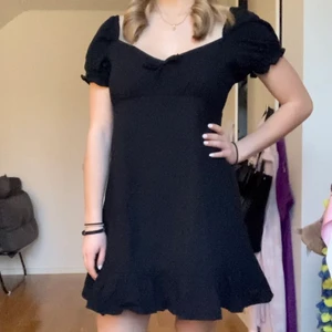 Svart klänning - Fin svart kortklänning. Passar på både domaren och vintern. Puffärmar, rosett för fram och snygg rygg! Aldrig använd 