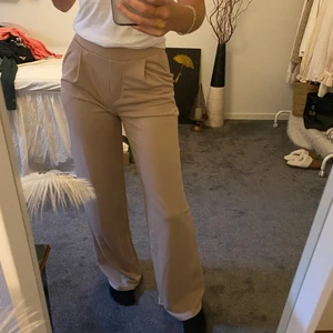 Kostymbyxor från Nelly - Ett par ljusrosa byxor ifrån Nelly.com.🥰 Supersköna nu till hösten och vintern då byxan har dubbeltyg. (Se sista bilden). Jättesköna och har en härlig fin rosa färg! Storlek XS. Säljes pga kommer inte så mycket till användning. Köpare står för frakt, annars möter jag gärna upp i Vänersborg 🤗