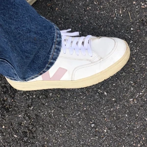 VEJA sneakers  - Så snygga sneakers från VEJA i modell V-12. Vita med ljusblå detalj bak samt lila detalj på kant. Lite slitningar men absolut i fräscht skick 💛 skiv för fler frågor eller bilder!! Nypris 1350kr