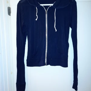 Hollister - luvtröja - En tunn marinblå luvtröja från Hollister. Kort i modellen med långa ärmar och stor luva. Köpare står för frakt.