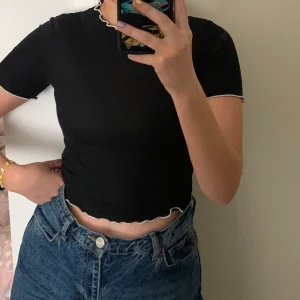 Topp Zara S - Svart topp med vita sömmar från Zara strl S. Tight passform.