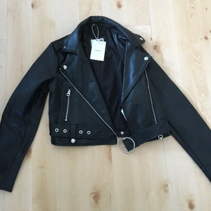 Bershka croppad läderjacka  - Helt oandvänd svart läderjacka från Bershka! Har fortfarande prislappar kvar! Original pris 400kr. Är i storlek s, köpare står för frakt!