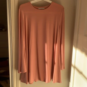 Klänning - En lös rosa klänning i storlek M. Ärmarna är utvidgade 