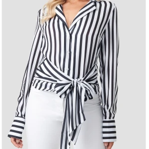 Skjorta med knytning - Svart skjorta med knytning där fram. Från NA-KD storlek 38