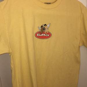 Gul Butter T-Shirt med litet tryck på bröstet. Skick 9/10. Storlek M