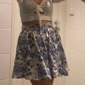 Blommig kjol - Perfekta blommiga kjolen! Går att vika upp i midjan och på så sätt justera längden. 