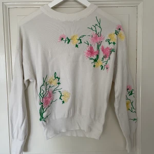 Vit tröja med broderade blommor  - Fin tröja i bra skick! Broderade blommor av hög kvalite. Spårbar frakt med DHL inräknad i priset!