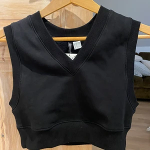 Svart väst  - Croppad väst. Oanvänd med prislapp kvar eftersom jag råkade köpa fel storlek och inte hittat kvittot. Kan använas som den är eller med en tshirt eller skjorta under!