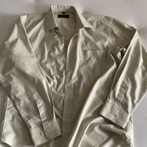 Grön Hugo boss skjorta - Grön Hugo boss skjorta. Står ingen storlek men skulle säga att den är en L. Har lite vitt mönster i sig med ett litet märke på bröstfickan 