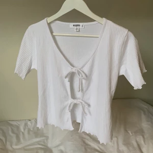 Vit topp med knytning! - Vit ribbad topp med dubbel knytning framtill, från Missguided Tall. Passar alltså extra bra om man är över 170. Använd en gång så är i nyskick!