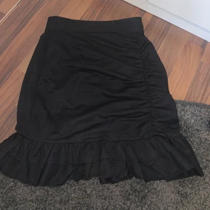 Bik Bok svart kjol  - Svart kjol med volanger nertill. Storleken är XS. Denna kjol är helt oanvänd och köptes för ca 2 månader sedan. Den är alltså i helt nytt skick. Dock finns prislappen ej med