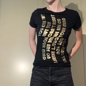 T-shirt med tryck (ZARA) - Svart T-shirt från Zara med guldig text ”You can try but you can’t resist we are on you mind”. Storlek M men passar mig som har S/XS. Figursydd men stretchig.