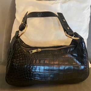 väska - Säljer en superfin väska från Nelly med gulddetaljer! Den är i  mycket bra skick. Skriv vid intresse⭐️⭐️