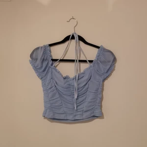 Blå croptop i mesh - Blå croptop med halterneck-knytning från Dollskill. Aldrig använd, bara provad!