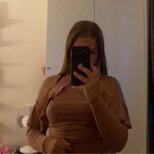 Rosa tröja - En gammelrosa långärmad top från Nelly med volanger och hål vid axlarna som har använts ca. 3 gånger