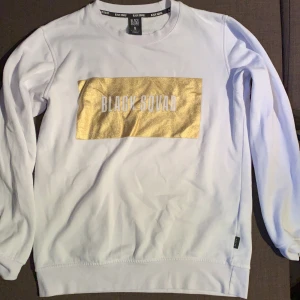 Vit tröja med guld tryck - Oversized modell, tyget andas och lätt att tvätta. Använd två gånger.