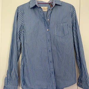 Blå skjorta med vita ränder i stolek 34  - En Holly and Whyte skjort från Lindex i stolek 34. Endast använd ett fåtal gånger!                                         Köparen står för frakten