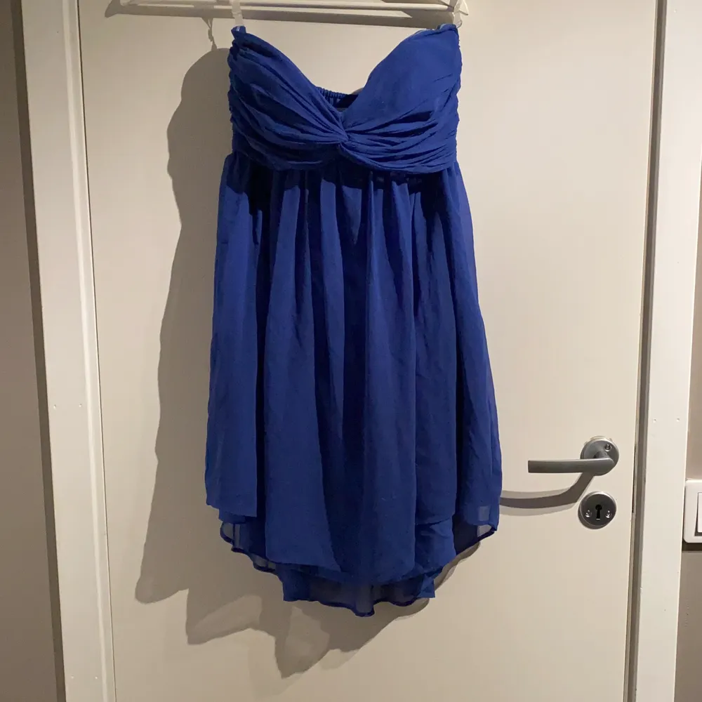 Blå klänning i modell mini, utan axelband. Klänningar.