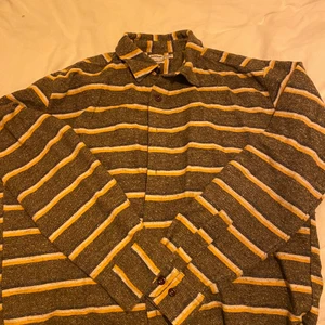 Randig skjorta  - En snygg randig skjorta i brun och gult! Storlek L men passar helt klart även M! Den är i bra skick! Köparen står för frakten (66kr) 🥰