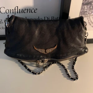 Zadig väska - Säljer eventuellt min zadig et Voltaire väska. Svart/mörkgrå i läder. Kort och långt band tillkommer. Långt band lite sönder på ett ställe.