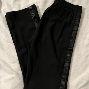 Kostymbyxor med sidenrand  - Ett par superfina kostymbyxor från Bik Bok med en svart sidenrand på sidan. Raka byxor med reså i midjan! Hör av er vid frågor✨ Storlek S
