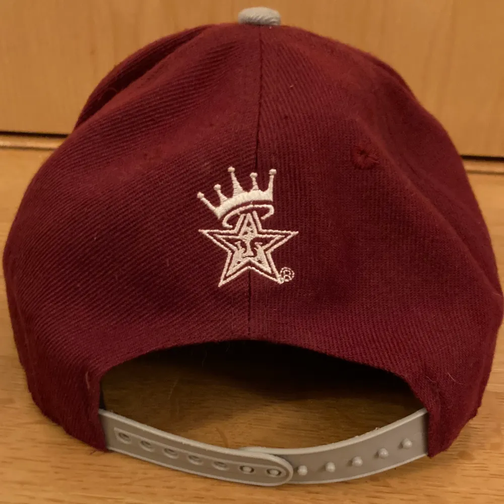 A wine red and gray baceball cap with golden.. Accessoarer.