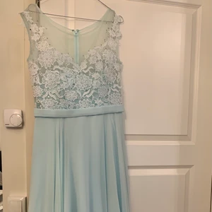 Festkläning klänning  - Klänning i nästan helt ny skick, använd endast bara en gång. I en fantastik ljusblå färg, med silvriga detaljer. Perfekt för evenemang av olika slag