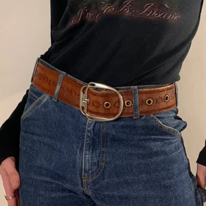 brunt läder bälte blommor silver spänne - Brunt vintage läder bälte med blommönster längs hela 🧳 Bältet är 100 cm långt och 4,7 cm brett! Detta är det perfekta bältet för hösten då det är elegant men fortfarande mysigt och i en naturlig färg som passar till allt! En så fin detalj är också att hålen är av metall vilket gör detta detaljrika bältet ännu bättre!