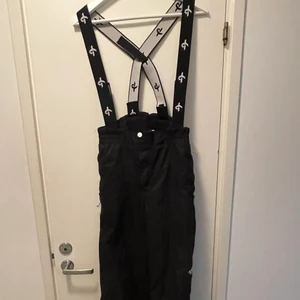 Overall byxor - Ett par svarta overall byxor för barn i god kvalite. Använda en vinter och är i samma skick som nya. Köpta från Stadium tror jag. Perfekta skidbyxor.