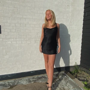 Svart satinklänning - Har använt klänningen ca 3 gånger men den har blivit för liten för mig efter denna sommaren haha. Klänningen är från Bershka i storlek S. Köparen står för frakt (66kr)