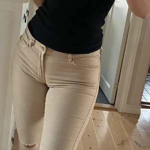 H&M Jeans beige med hål  - Jättefina beiga jeans med små hål vid knäna. Säljer pga att de ej kommer till användning. Passar dig är 170-173 cm lång ungefär, storlek S 
