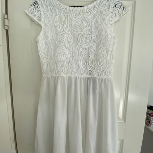 Ayla dress white från Bubbleroom - Superfin vit klänning i storlek 38. Perfekt för student/avslutning. Aldrig använd, säljer på grund av felköp av storlek. Ordinarie pris 599kr. Överdelen är i stretchig, fodrad spets och underdelen i fodrad mers. V-ringad i ryggen med vackra knappar och en dold dragkedja.